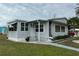 Single-wide manufactured home with gray siding, steps, and landscaping at 5327 Glen Echo Ave, Sarasota, FL 34234