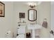 Small powder room with pedestal sink and ornate mirror at 550 Yardarm Ln, Longboat Key, FL 34228