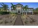 Two-story home with double garage and brick pathway at dusk at 550 Yardarm Ln, Longboat Key, FL 34228