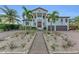 Two-story home with a grand entrance, lush landscaping, and a large driveway at 550 Yardarm Ln, Longboat Key, FL 34228