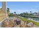 Patio with firepit and seating area overlooking canal at 550 Yardarm Ln, Longboat Key, FL 34228