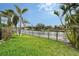 Grass lawn and canal-front view with private dock at 5830 Gulf Of Mexico Dr, Longboat Key, FL 34228