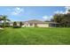 Spacious backyard with grassy lawn and screened enclosure at 5890 Guarino Dr, Sarasota, FL 34238