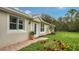 Home's side view, showcasing a white door, plant, and grassy lawn at 5890 Guarino Dr, Sarasota, FL 34238