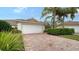 Well-maintained house with a white garage door and a brick driveway at 5890 Guarino Dr, Sarasota, FL 34238