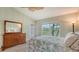 Bedroom with a queen bed, dresser, and large window offering a garden view at 5911 Doral Dr, Sarasota, FL 34243