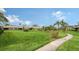 Landscaped community featuring a paved pathway and lush green lawn at 5911 Doral Dr, Sarasota, FL 34243