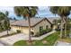 Exterior view of a villa with a two-car garage and lush landscaping at 5911 Doral Dr, Sarasota, FL 34243