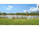 Serene lake view with grassy shoreline and birdhouse at 5911 Doral Dr, Sarasota, FL 34243