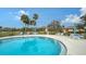 Relaxing kidney-shaped community pool with lounge chairs at 5911 Doral Dr, Sarasota, FL 34243