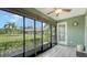 Bright sunroom with sliding glass doors, ceiling fan, and lush landscaping view at 5911 Doral Dr, Sarasota, FL 34243