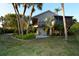 Charming home exterior with a large screened-in porch and balcony surrounded by lush tropical landscaping at 631 43Rd Street W Blvd, Palmetto, FL 34221