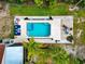 Aerial view of a backyard pool and patio area with plenty of seating surrounded by green grass and tropical palm trees at 631 43Rd Street W Blvd, Palmetto, FL 34221