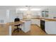 Galley kitchen with white cabinets and wood floor at 6424 18Th E Ave, Bradenton, FL 34208