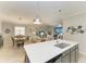 Open kitchen island with sink, looking toward living and dining areas at 6579 Willowshire Way, Bradenton, FL 34212