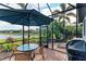 Relaxing screened patio with lake view, outdoor dining area, and grill at 6579 Willowshire Way, Bradenton, FL 34212