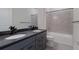 Bathroom with double sinks, tub, and dark vanity at 712 Sigsbee Loop, Sarasota, FL 34240