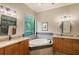 Elegant bathroom with a corner soaking tub, dual sinks, and granite countertops at 7312 Riviera Cv, Lakewood Ranch, FL 34202