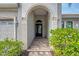 Inviting entryway with arched detail, tile flooring, and lush landscaping at 7312 Riviera Cv, Lakewood Ranch, FL 34202