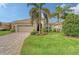 Single-story home with landscaped yard, paver driveway, and two-car garage at 7312 Riviera Cv, Lakewood Ranch, FL 34202