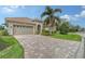 Luxury home with a large driveway and tropical landscaping at 7312 Riviera Cv, Lakewood Ranch, FL 34202