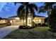 Well-lit home with a paved driveway and landscaped lawn at 7312 Riviera Cv, Lakewood Ranch, FL 34202