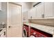 Laundry room with red LG washer and dryer, granite countertop at 7312 Riviera Cv, Lakewood Ranch, FL 34202