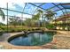 Enclosed kidney-shaped pool with brick coping and water features at 7312 Riviera Cv, Lakewood Ranch, FL 34202