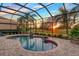 Relaxing kidney-shaped pool with a screened enclosure and sunset views at 7312 Riviera Cv, Lakewood Ranch, FL 34202