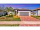 Single-story home with gray garage door and brick driveway at 7432 Summerland Cv, Lakewood Ranch, FL 34202