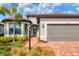 Front view of the house with gray garage and landscaping at 7432 Summerland Cv, Lakewood Ranch, FL 34202