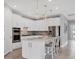 White kitchen with island and stainless steel appliances at 7432 Summerland Cv, Lakewood Ranch, FL 34202