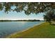 Sparkling lake view with grassy shoreline and homes in the background at 7575 Quinto Dr, Sarasota, FL 34238