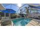 Inviting screened-in pool with patio furniture and umbrella for shade at 7575 Quinto Dr, Sarasota, FL 34238