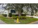 Landscaped front yard with mature tree and yellow fire hydrant at 8414 Imperial Cir, Palmetto, FL 34221