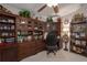 Home office features built-in wooden shelving and cabinets, providing ample storage at 8414 Imperial Cir, Palmetto, FL 34221