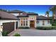 White two-story house with brown roof, three-car garage, and manicured landscaping at 8994 Wildlife Loop, Sarasota, FL 34238