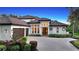 Two-story home with a tile roof, three-car garage, and a brick driveway at 8994 Wildlife Loop, Sarasota, FL 34238