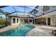 Relaxing kidney shaped pool with screened enclosure and patio furniture at 8994 Wildlife Loop, Sarasota, FL 34238