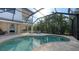 Relaxing kidney shaped pool with screened enclosure and patio furniture at 8994 Wildlife Loop, Sarasota, FL 34238