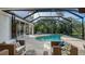 Relaxing kidney shaped pool with screened enclosure and patio furniture at 8994 Wildlife Loop, Sarasota, FL 34238