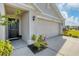 Front entrance with a dark door, two-car garage, and landscaping at 10328 Charlotte Dr, Parrish, FL 34219