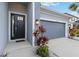 Modern front entrance with black door and gray garage door at 10531 Piedra Dr, Palmetto, FL 34221