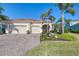 Tan house with tile roof, three car garage and palm trees at 12654 Harney St, Venice, FL 34293