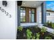 Modern front entrance with wood-paneled door and gray stone walkway at 13377 Alocasia Ln, Port Charlotte, FL 33981