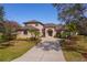 Two-story house with light brown exterior, a large driveway, and lush landscaping at 14901 17Th E Ave, Bradenton, FL 34212