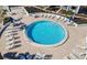 Aerial view of a circular pool surrounded by lounge chairs and patio tables at 1602 Stickney Point Rd # 1602-301, Sarasota, FL 34231