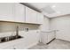 Laundry room with white cabinets, a utility sink, and ample storage at 1608 80Th Nw St, Bradenton, FL 34209