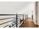 Upstairs hallway with modern railing and hardwood floors at 1608 80Th Nw St, Bradenton, FL 34209