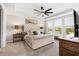 Main bedroom with tufted headboard, ceiling fan, and large windows at 16135 Paynes Mill Dr, Bradenton, FL 34211